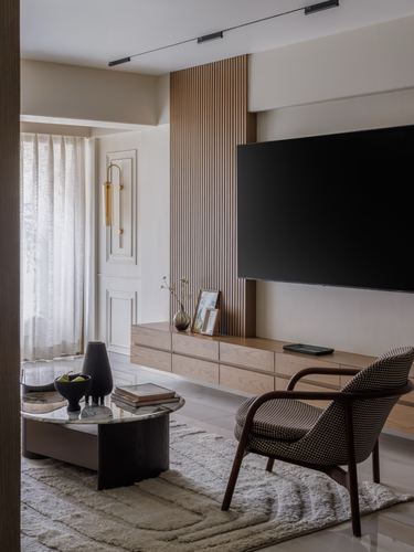 Living room with fluted wood panel, floating console, checkered armchair and round marble coffee table
