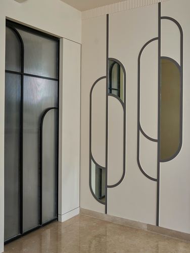 Foyer with arched glass door and wall of arched mirror-and-panel motifs on beige marble floor