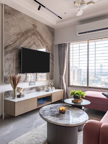 Living room with marble feature wall, floating wood console, round marble coffee table and pink sofa by window