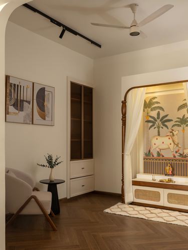 Living room corner with a carved wood pooja alcove featuring a pichwai-style mural and cane cabinetry.