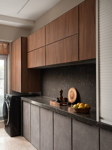 Wooden upper cabinets over dark stone counter and backsplash with fruit basket, kitchen corner