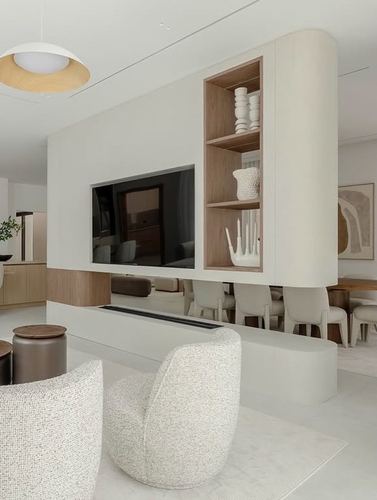 Curved white partition wall with tv niche and wood-lined shelves separating living and dining areas