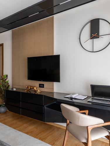 TV media unit and desk combo with oversized clock on textured wall in study nook