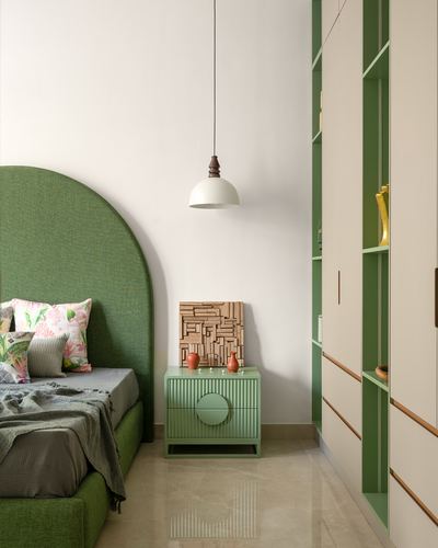 Green arched upholstered bed beside fluted green nightstand and pendant light, with green-cream wardrobe