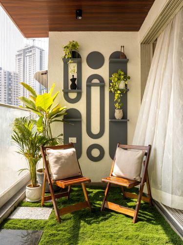 Balcony with folding wood chairs, artificial turf, and sculptural grey shelf art on wall