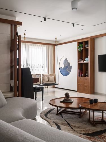 Living room with hanging wooden swing, round coffee tables, and wooden display shelving unit