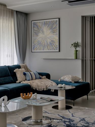 Teal velvet sectional sofa beneath a framed starburst artwork in a modern living room