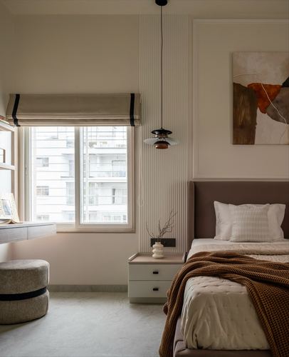 Bedroom corner with upholstered headboard, pendant light, fluted panel wall and window with roman blind