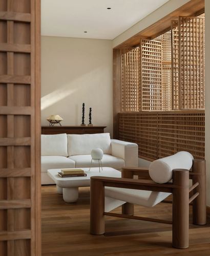 Living room with white sofa, wooden armchair, and carved timber lattice screen wall