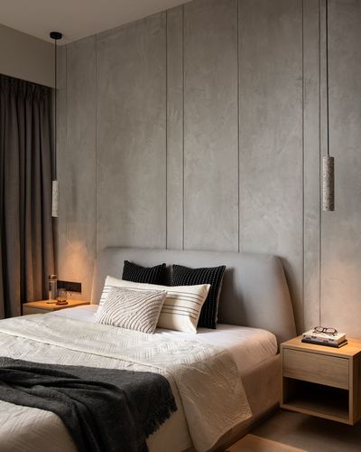 Minimalist bedroom with textured plaster wall, upholstered bed, and terrazzo pendant lights over wooden nightstands