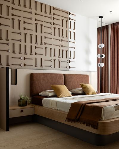 Bedroom with textured carved wall panel above a rust upholstered headboard and mustard pillows