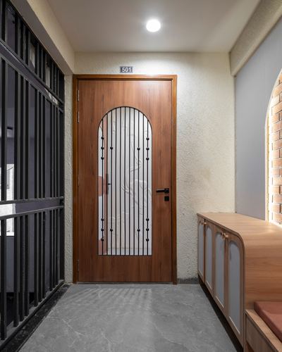 Textured foyer passage with wooden door bearing an arched glass and grille panel, numbered 501