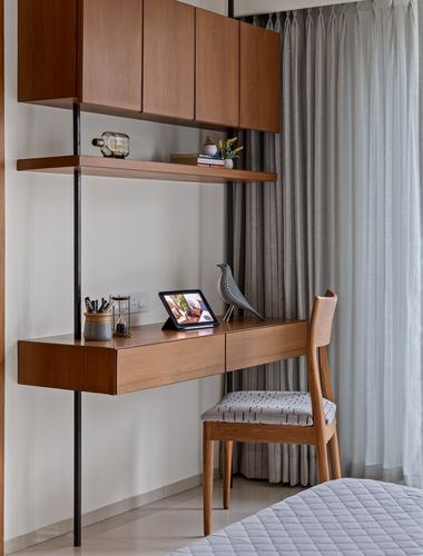 Wall-mounted wooden study desk with chair, shelving, and cabinets against sheer curtains