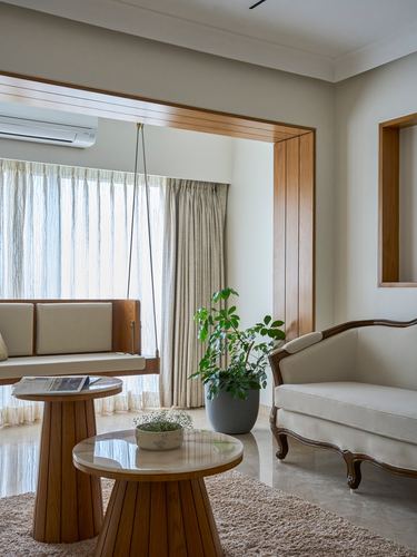 Living room with wooden swing, round wood coffee tables, cream sofa and marble floor