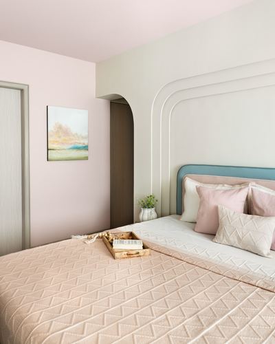 Pastel pink bedroom with arched cove headboard wall and teal upholstered bed