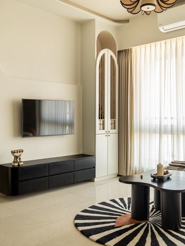 Monochrome living room corner with black console, arched cabinet, and zebra rug