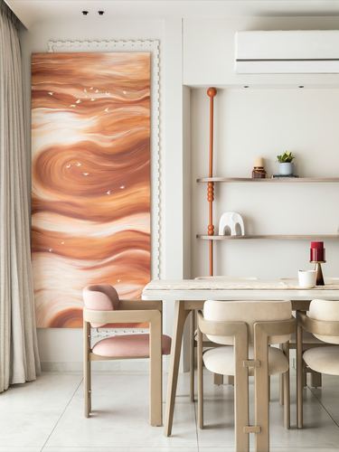 Dining area with large terracotta abstract painting, pink armchair, and wooden dining table.