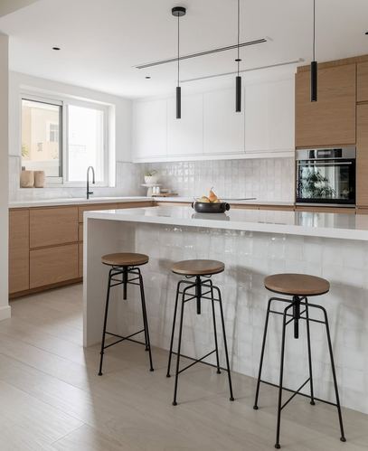 White kitchen with wood cabinetry, tiled waterfall island and three black metal bar stools