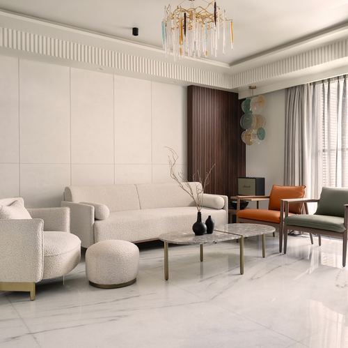 Neutral living room with boucle sofa, marble coffee table, and orange and green accent chairs