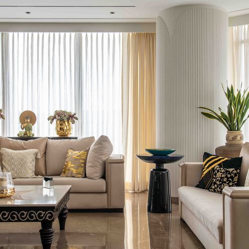 Beige living room with fluted column, sheer curtains, marble floor and layered pillows
