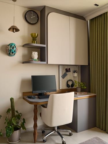 Compact study nook with wall-mounted shelving, desk, monitor, and olive curtain by window
