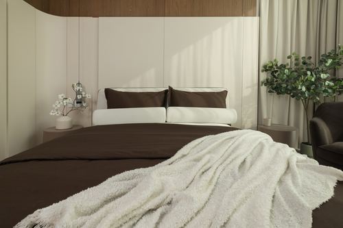 Bedroom with curved panelled wall, brown bedding, cream throw, and pendant light in sunlight