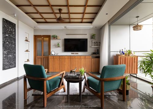 Living room with teal armchairs facing a wood console under a coffered wood ceiling