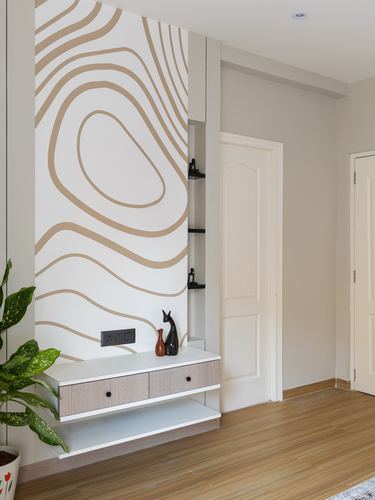 Foyer with contour-patterned wallpaper wall and floating wood console beside white doors
