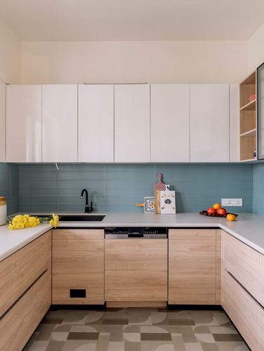 L-shaped kitchen with white upper cabinets, wood lower cabinets, and teal tiled backsplash