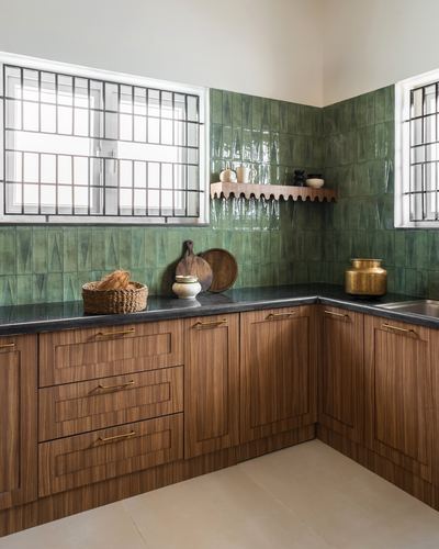 L-shaped kitchen with glossy green tile backsplash, dark stone counters, and wood-grain cabinetry