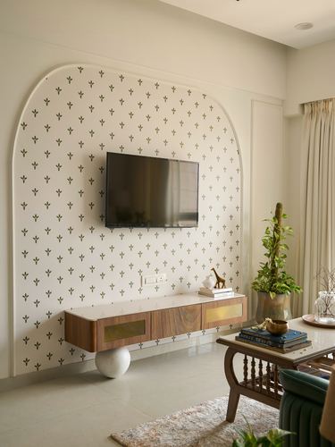 Living room with arched block-print wall, mounted TV, and floating wood console with brass inlay