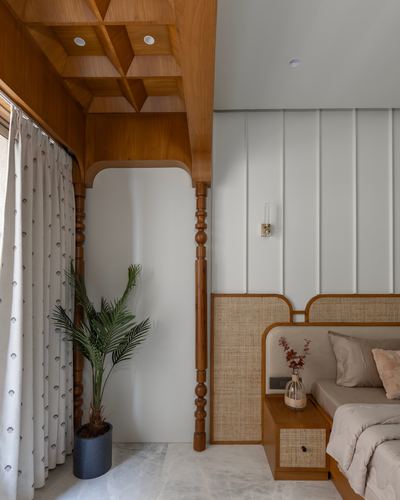 Bedroom corner with turned wood pillar, coffered ceiling, arched niche and cane headboard