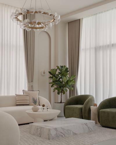 Neutral living room with olive velvet chairs, marble coffee table, and sculptural glass chandelier