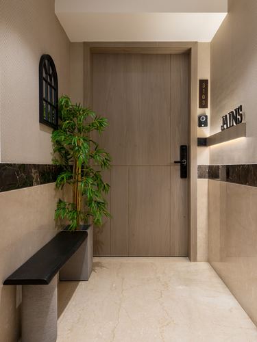 Apartment entrance corridor with wood door, marble wainscoting, arched mirror and bamboo plant