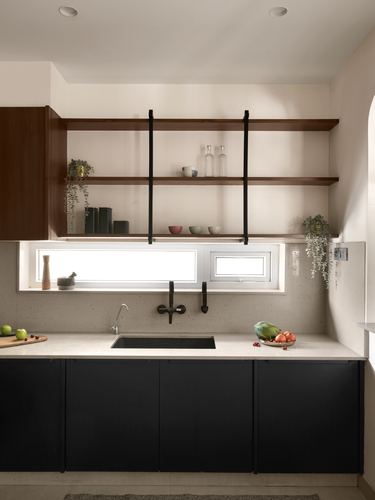 Kitchen with black cabinetry, stone countertop, wall-mount faucet and suspended wood shelves above window