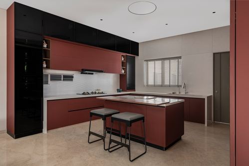 Terracotta and black modern kitchen with central island and two grey stools