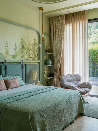 Green bedroom with mural headboard, curved shelving, and sheer curtains onto a garden view