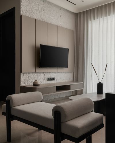 Minimalist living room with wall-mounted tv, textured plaster panel, and bolster-armed bench seat