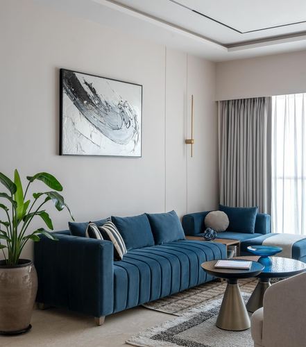 Living room with deep blue channel-tufted sofa, abstract art, and layered curtains by window