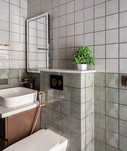 Bathroom with sage green textured tiles, brass fittings, vessel sink and mirror