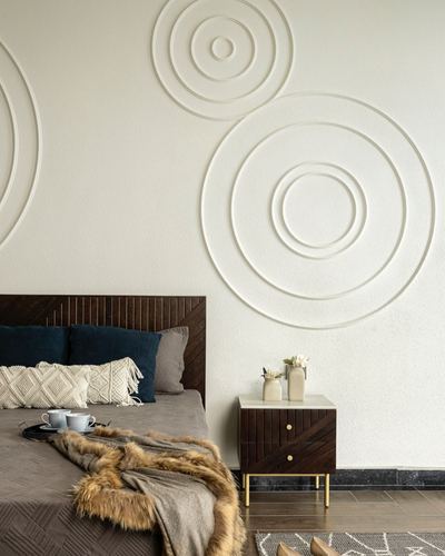 Bedroom with textured circular wall moulding, dark wood headboard, and marble-topped bedside table