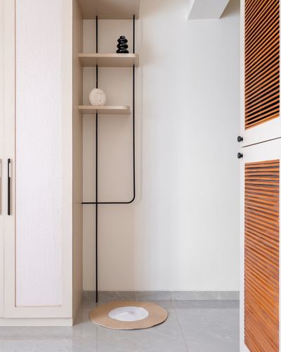 Beige foyer corner with black metal shelf frame and fluted wood door