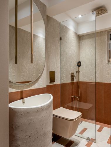 Bathroom with textured plaster walls, terracotta tile band, sculptural stone basin, and glass shower.