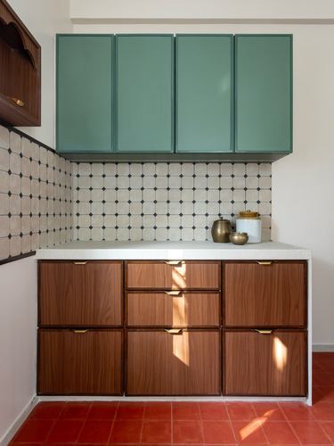 Kitchen with teal upper cabinets, patterned tile backsplash, wood lower cabinets, terracotta floor