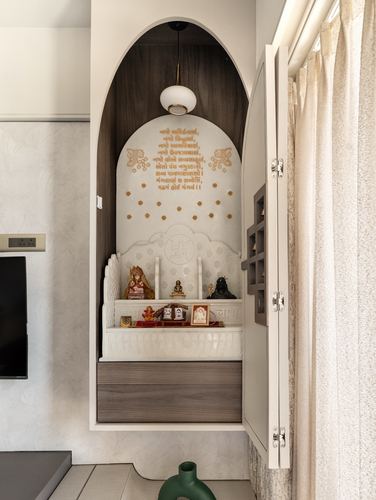 Arched wooden pooja niche with marble backdrop, mantra text, idols and pendant light