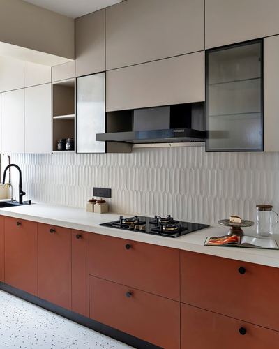 Modern kitchen with terracotta lower cabinets, beige upper units, and textured white backsplash tile