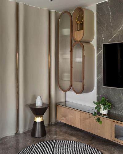 Living room corner with fluted fabric wall, oval wood-framed glass cabinets, and marble tv wall