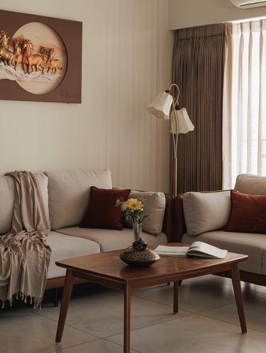 Beige sectional sofa with rust cushions, wooden coffee table, and a horse relief artwork on the wall