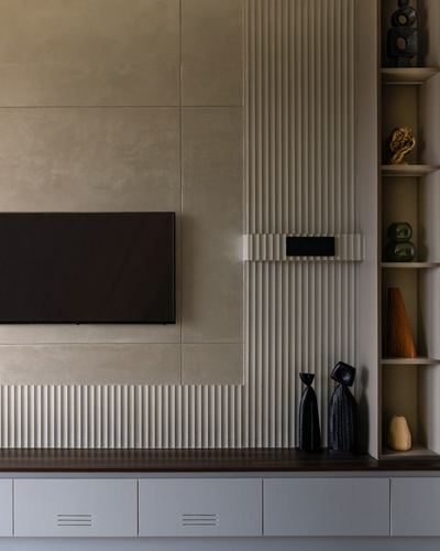 TV media wall with fluted panelling and open shelving styled with dark ceramic vases