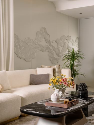 Living room with boucle sofa, carved wave wall panel, and black stone coffee table